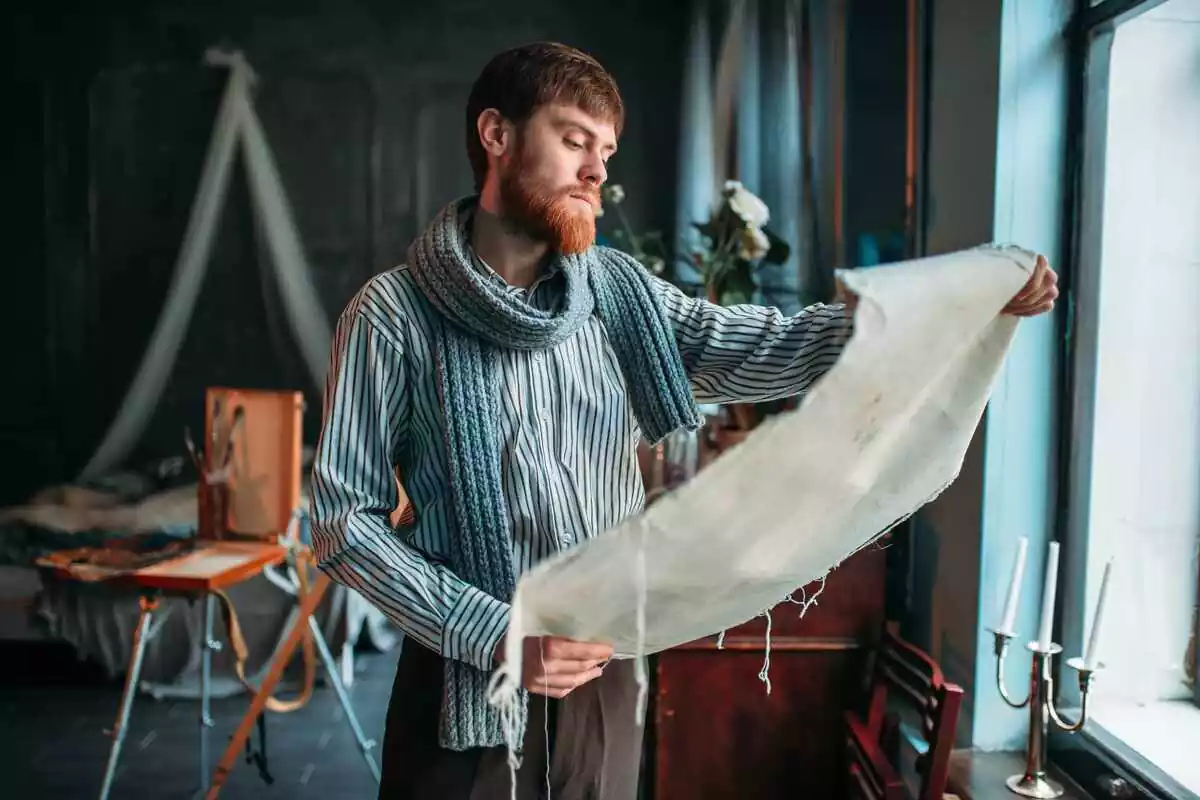 Pintor mirando su obra en un estudio