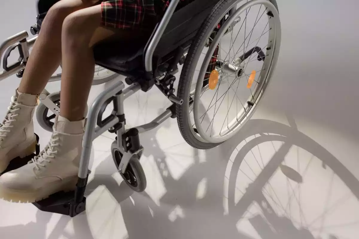 Una chica sentada en una silla de ruedas