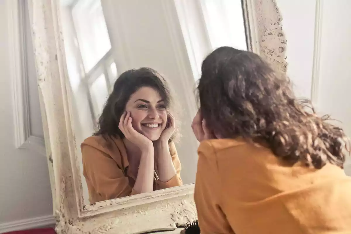 Una chica sonriendo a un espejo